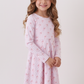 Young girl wearing a pink floral nightgown against a white background
