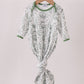 Green and white patterned baby outfit on a hanger against a light background